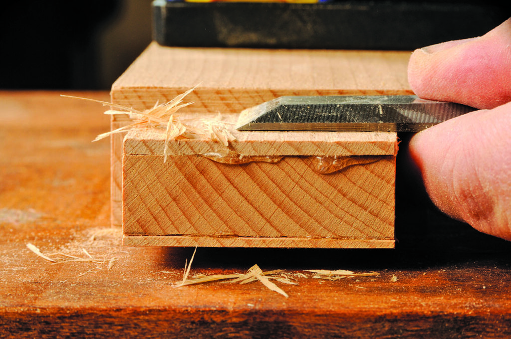 Chiselling wood block with precision and care.