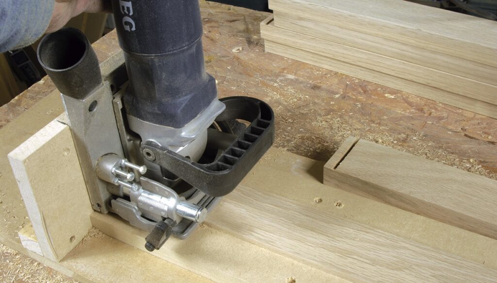 Biscuit joiner cutting groove in wooden board