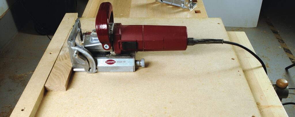 Biscuit joiner on woodworking table.