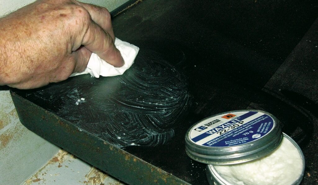Applying wax on metal surface with cloth