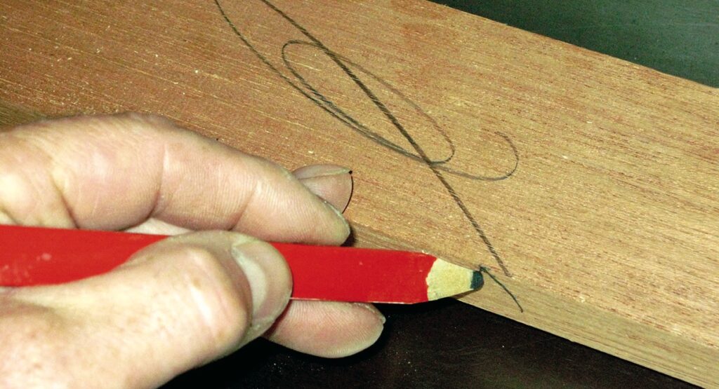 Hand drawing on wood with red pencil.