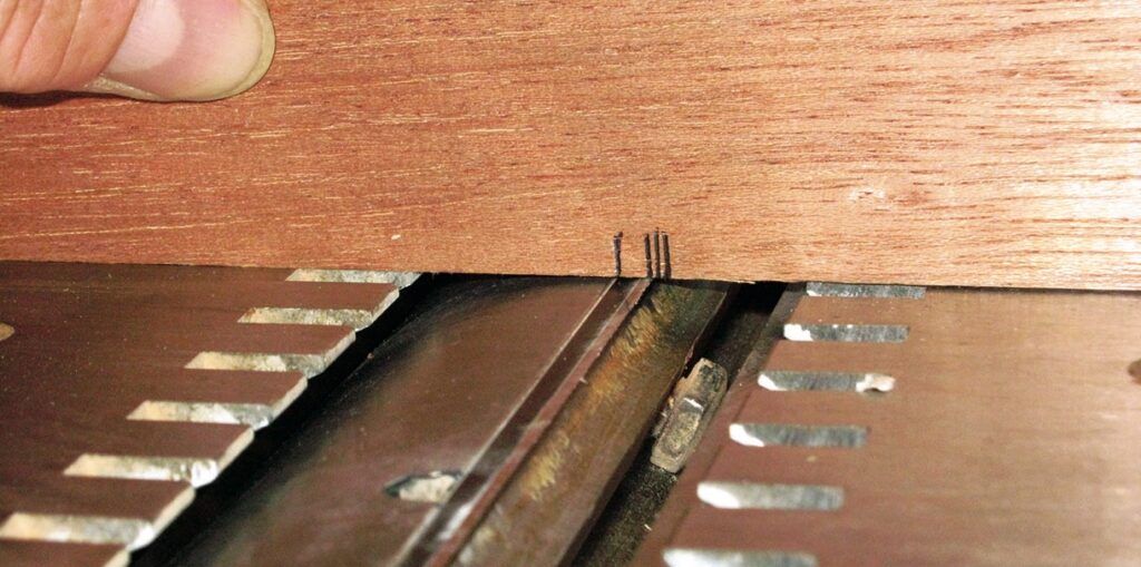 Wood marked for cutting on table saw blade.