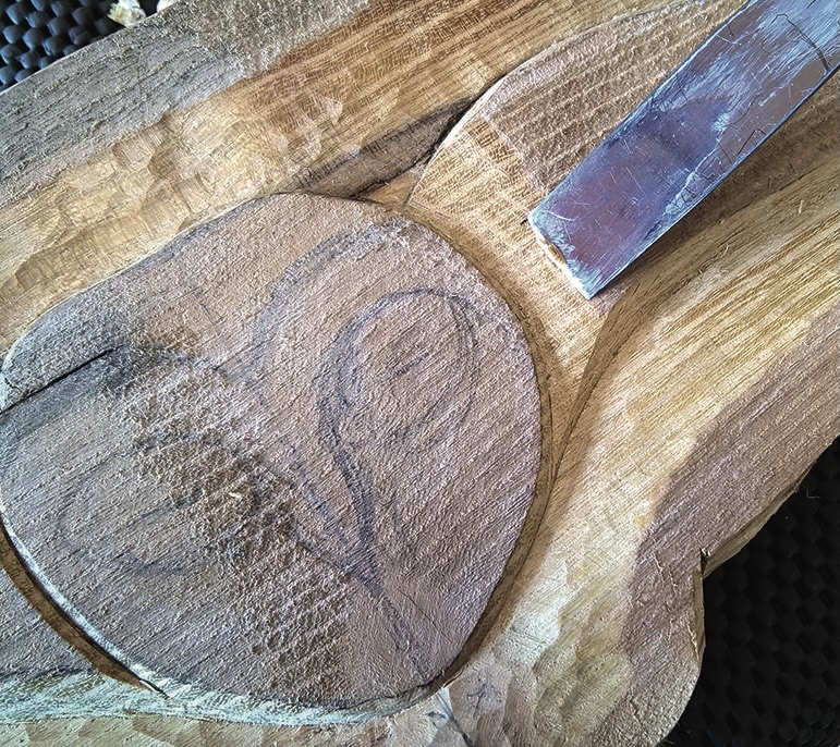 Wooden sculpture carving with chisel tool.