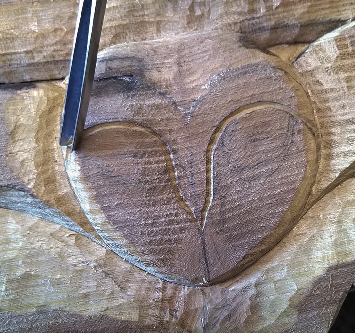 Chisel carving heart shape in wood