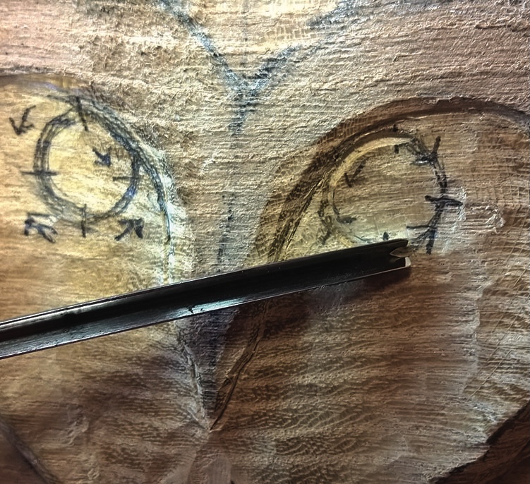 Wood carving of eyes with chisel