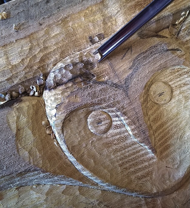 Wood carving progress showing owl face details.