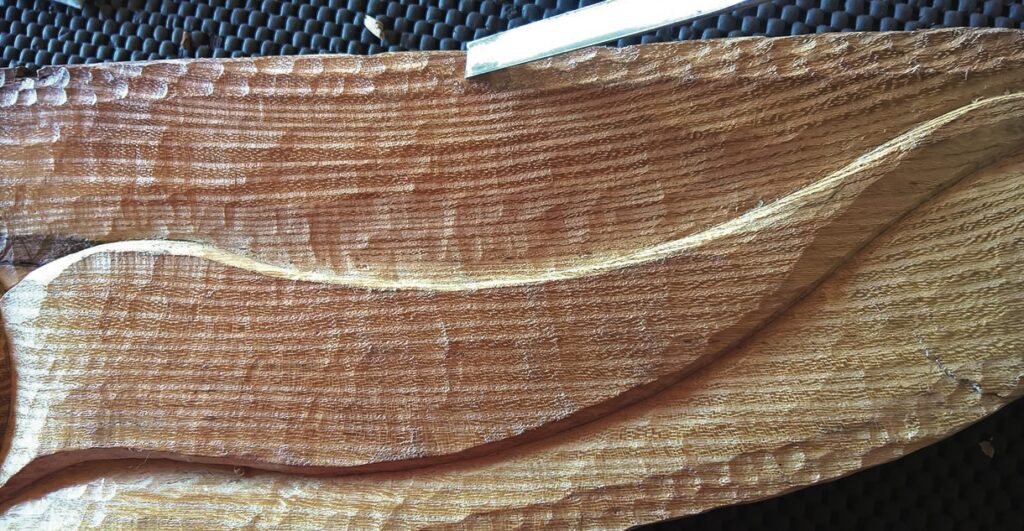 Close-up of wood carving with chisel detail.