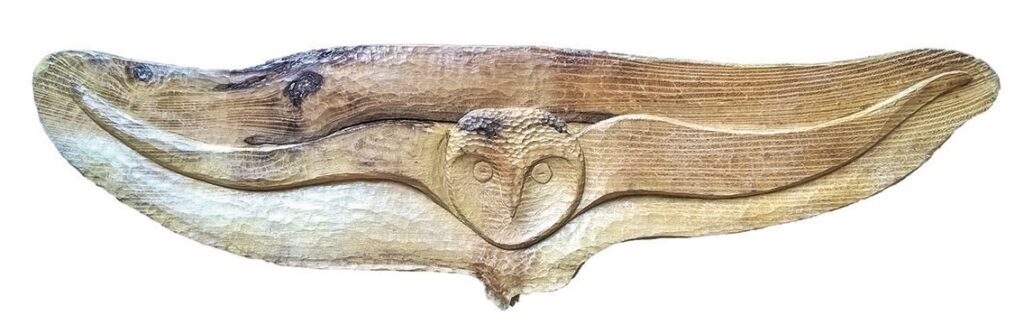 Wooden owl carving with outstretched wings.