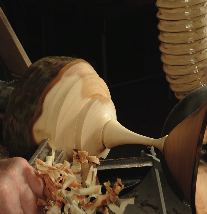 Woodturning on a lathe creating decorative bowl.