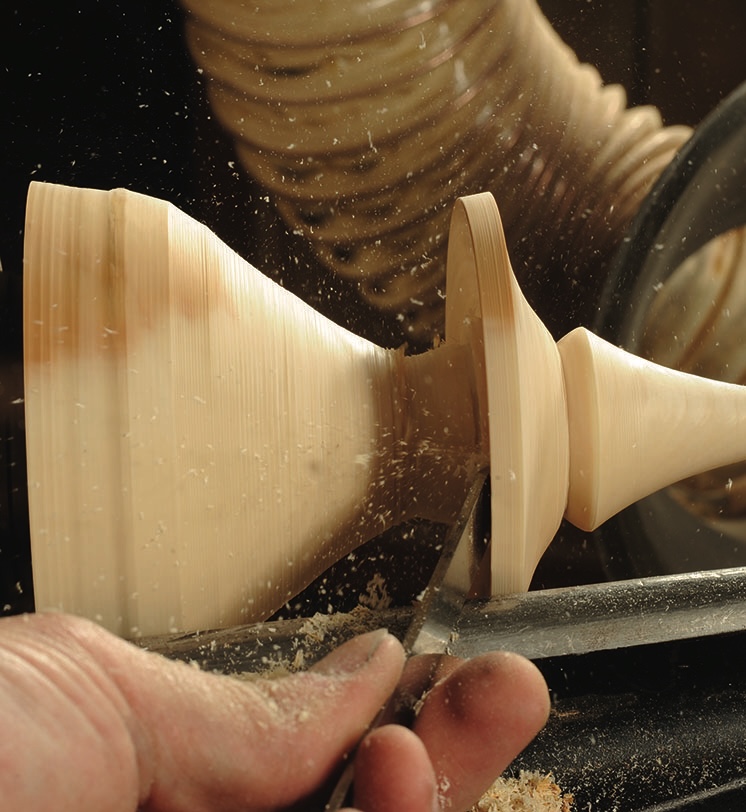 Woodturning with chisel on spinning lathe.