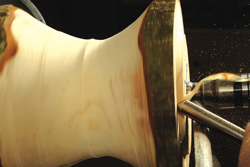 Woodturning a wooden bowl on a lathe.