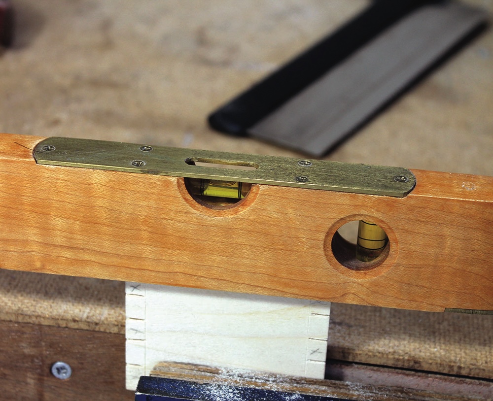 Wooden spirit level balancing on a surface.