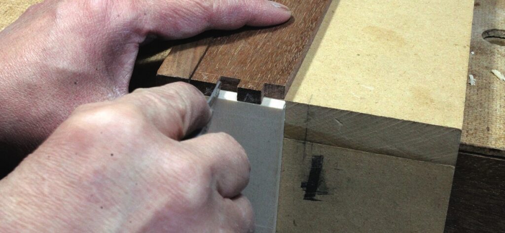 Craftsman chiselling wooden dovetail joint