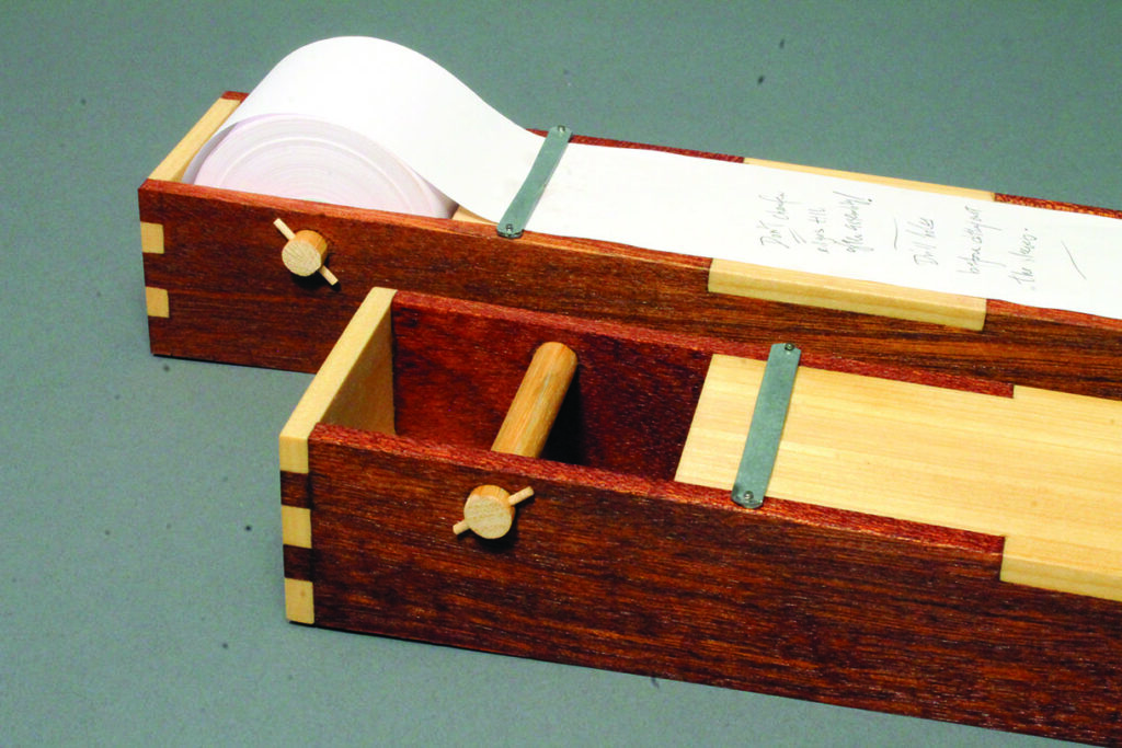Wooden box with scroll paper mechanism.