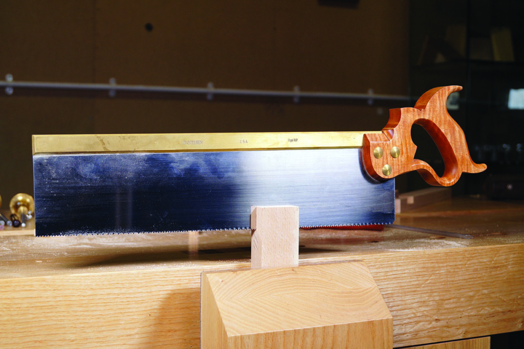 Backsaw on wooden workbench in workshop.