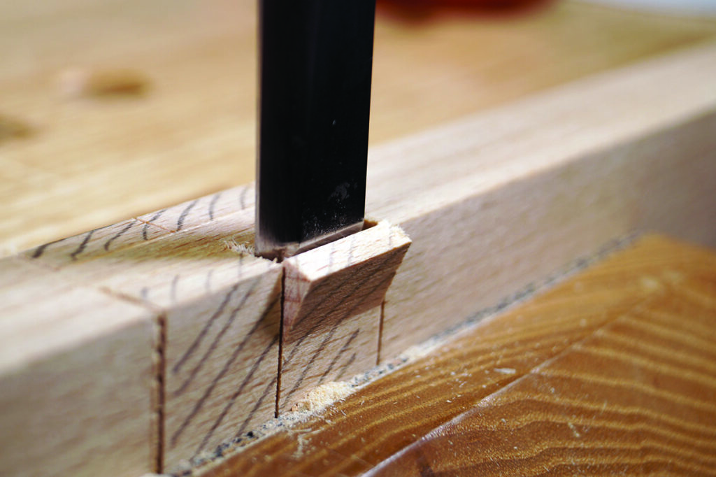 Close-up of saw cutting a wood joint.
