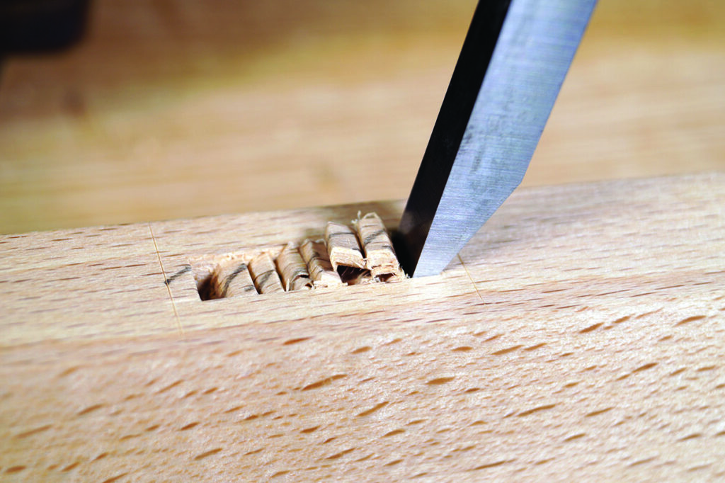 Woodworking chisel creating a precise mortise in wood.