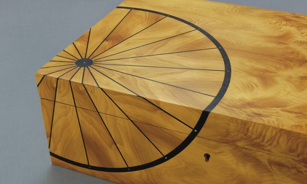 Wooden box with bicycle wheel design inlay.