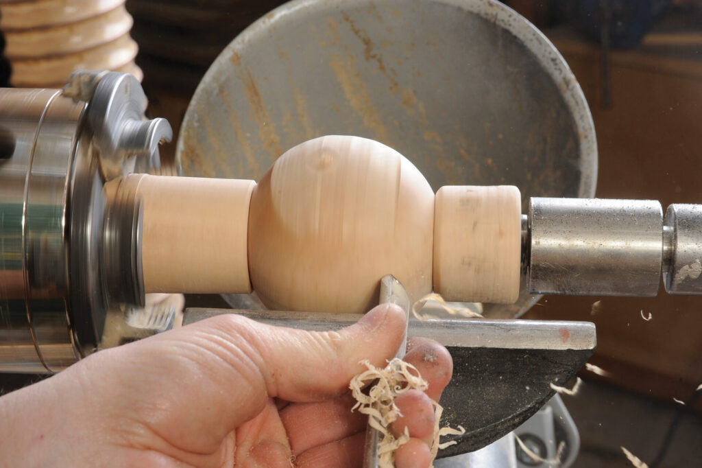Woodturning on lathe in workshop