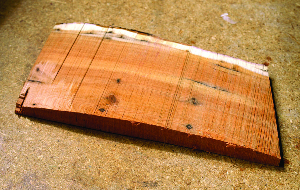 Rough-hewn wooden board on concrete surface.