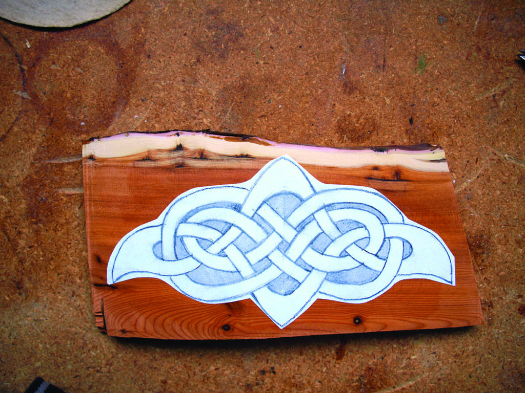 Celtic knot design sketched on wooden board