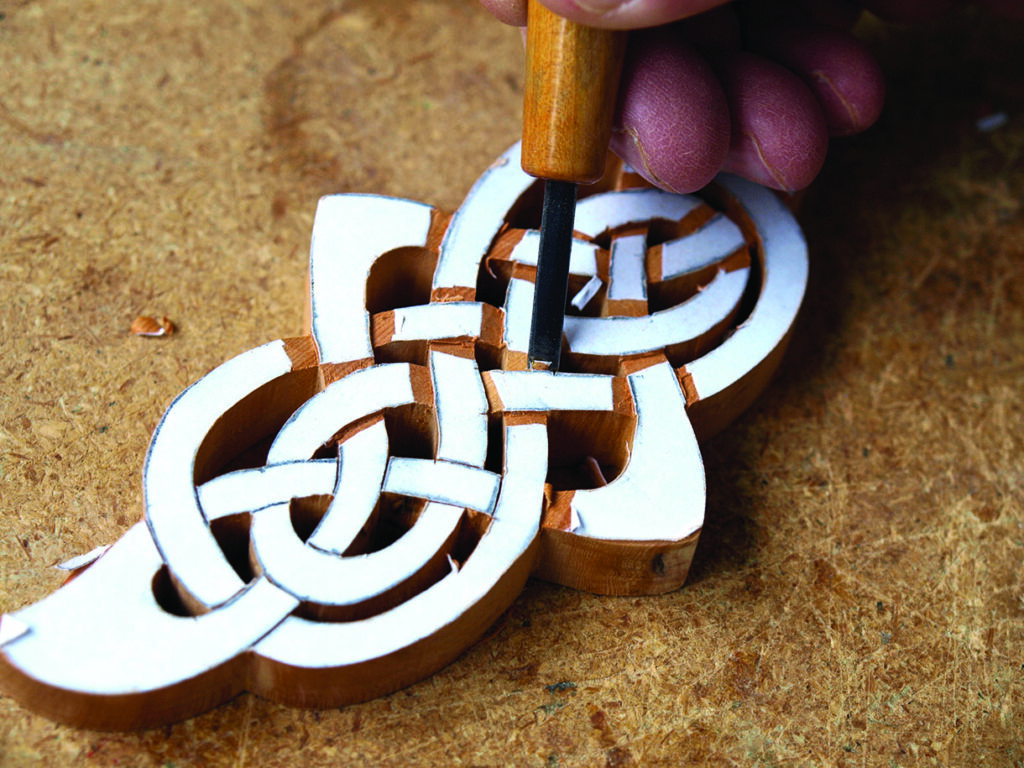 Carving wooden Celtic knot design by hand.