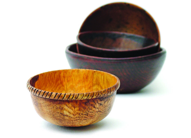 Stacked wooden bowls on white background