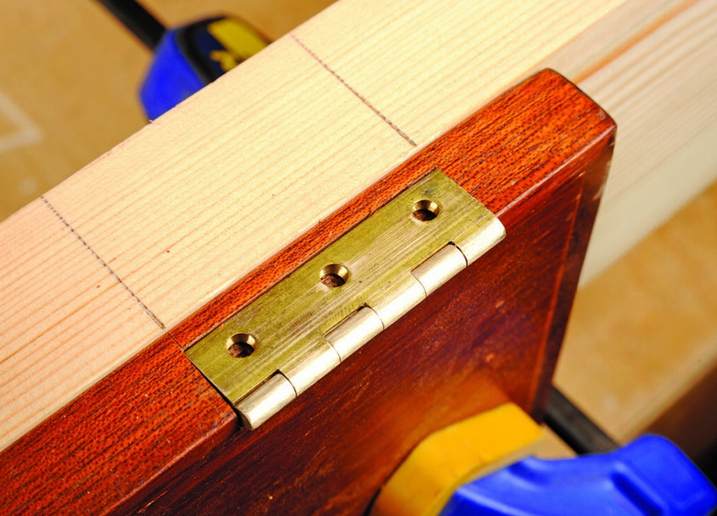 Wooden door with brass hinge and clamp