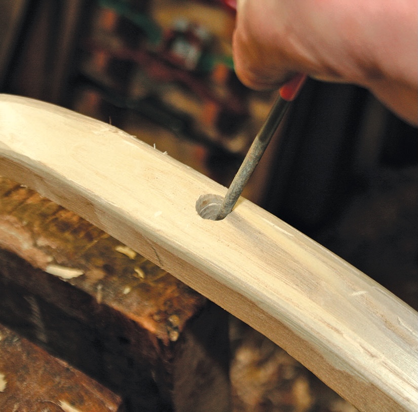 Carving wood with a hand tool.