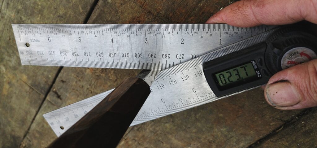 Person using digital angle finder on wooden surface.