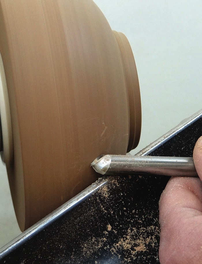 Woodturning with chisel on spinning lathe