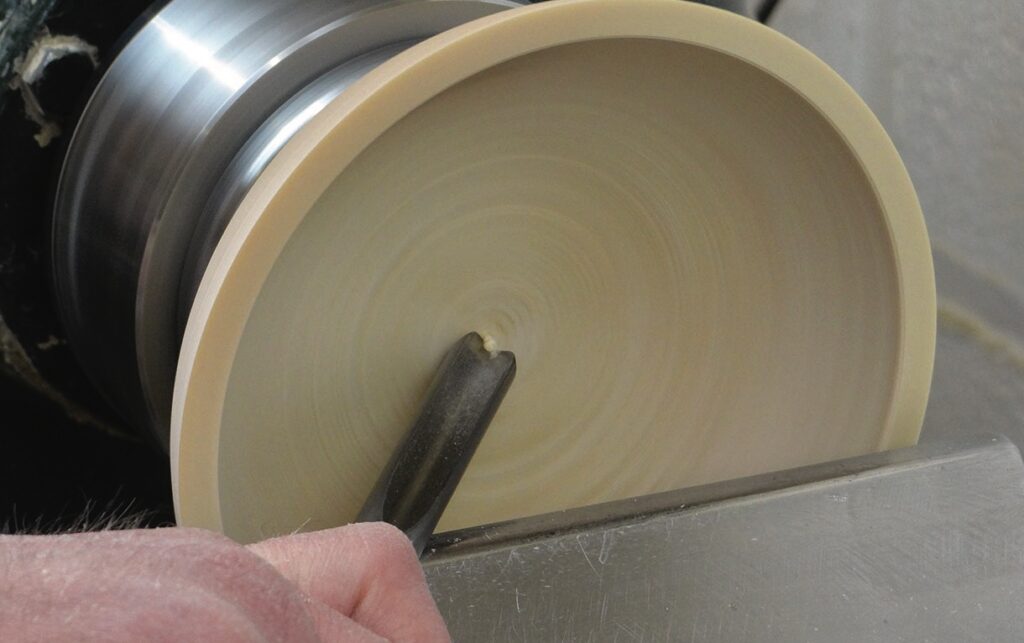 Woodturning with tool on rotating lathe