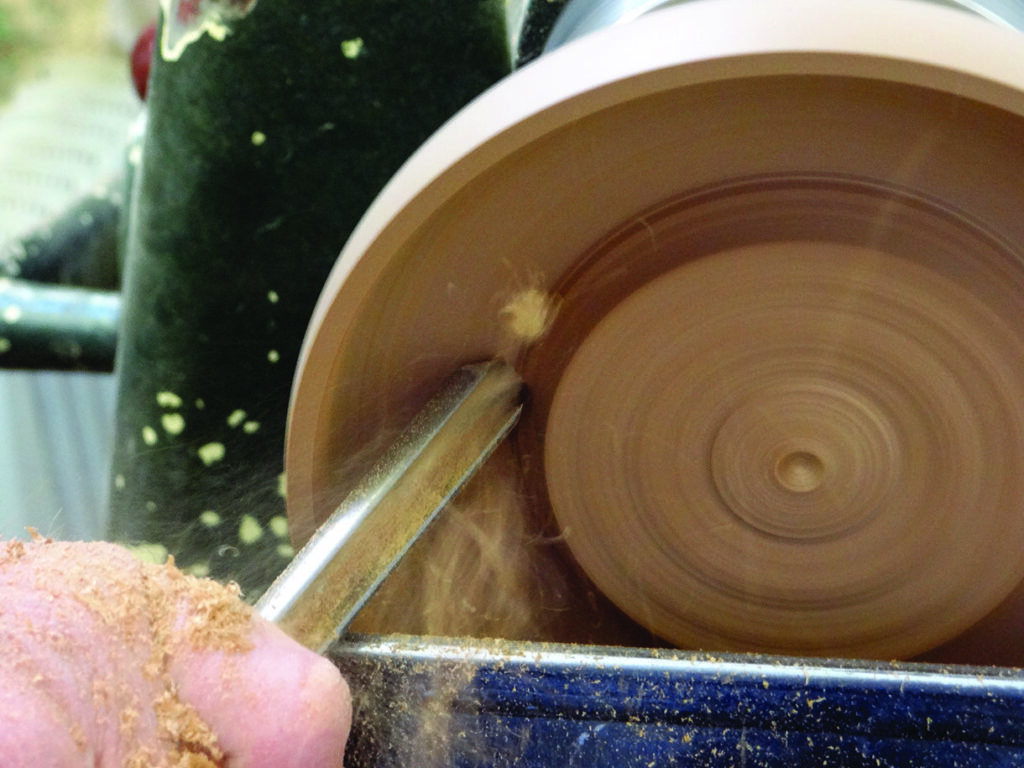 Wood turning on a lathe tool making bowl.