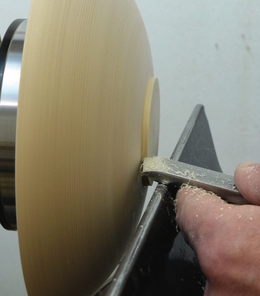 Woodturning with chisel on spinning lathe.