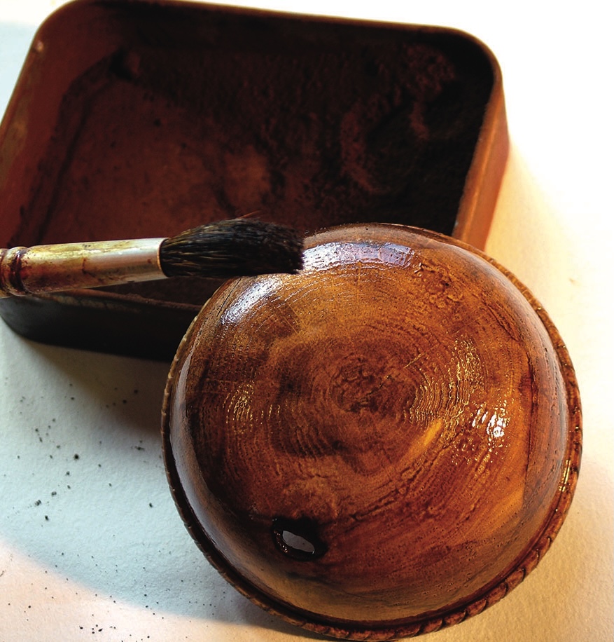 Wooden crafting bowl with paintbrush and stain.