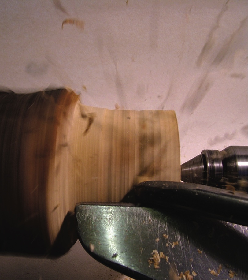 Woodturning a piece of wood on a lathe.