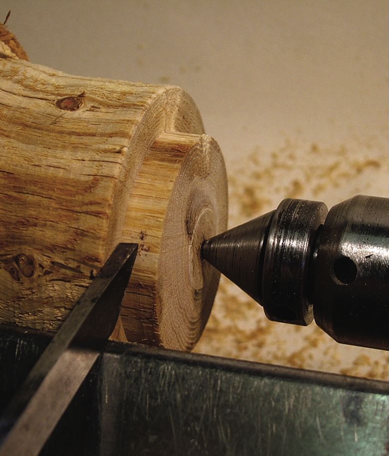 Woodturning lathe shaping wooden log