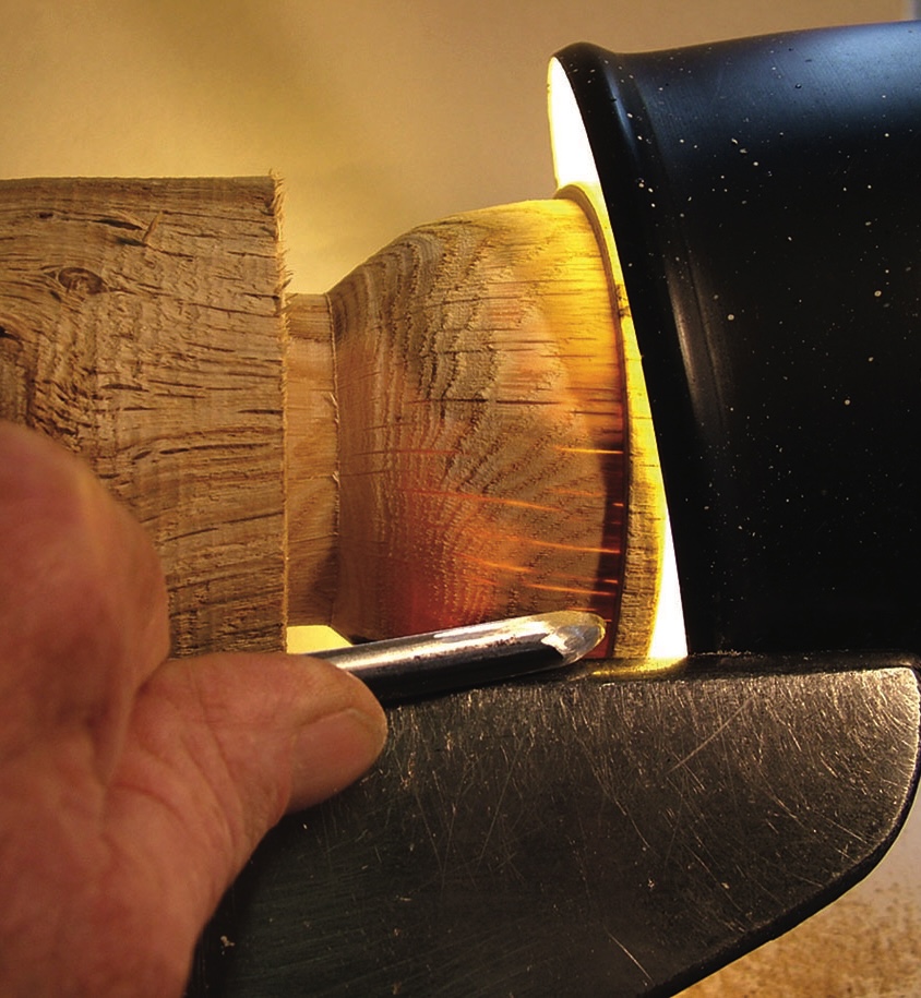 Woodworking with lathe and round gouge chisel.