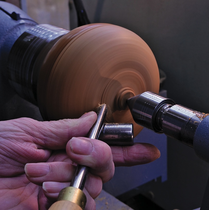 Person using lathe to shape wood.