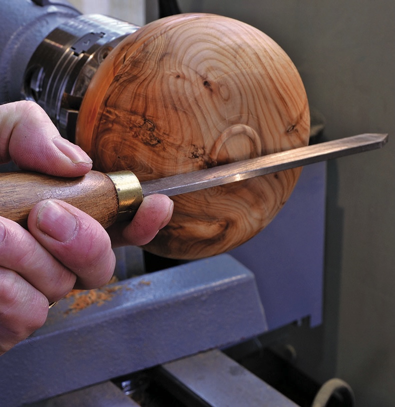 Wood lathe turning bowl with chisel