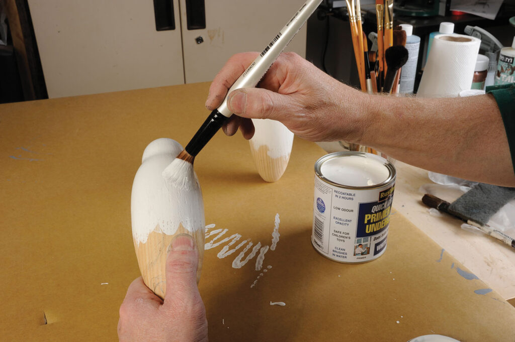 Hand painting wooden figure with primer.