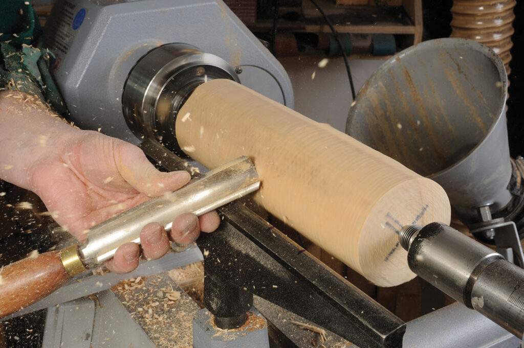 Woodturning on lathe with chisel.
