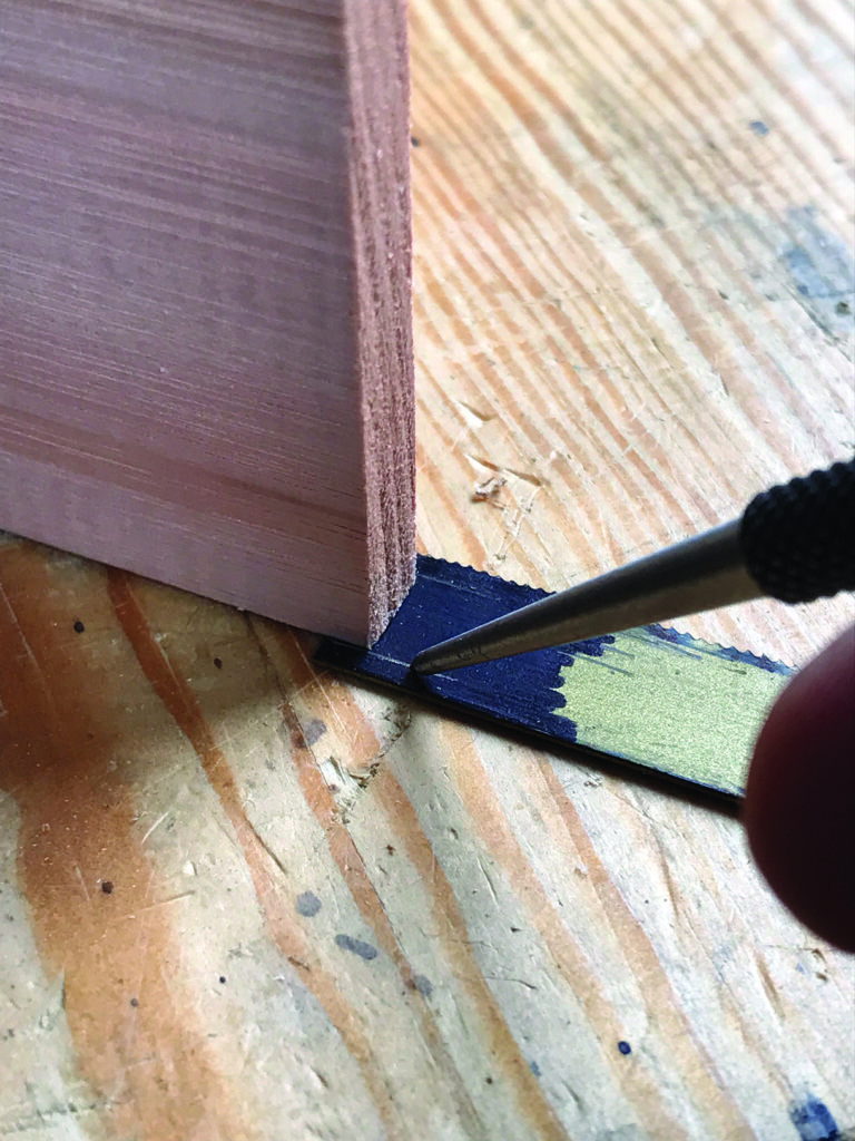 Marking wood with a pencil and square tool.