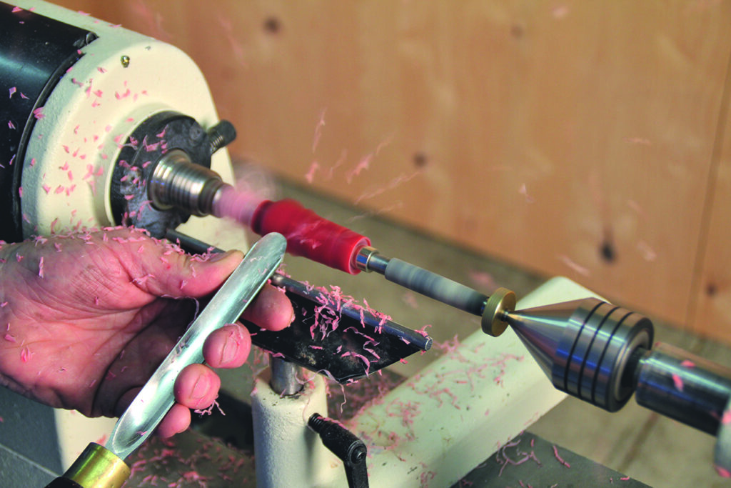 Person using wood lathe for carving