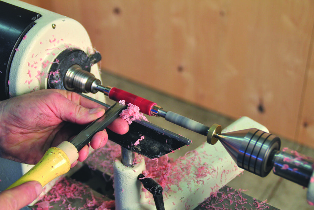Woodturning on a lathe with hand tools.