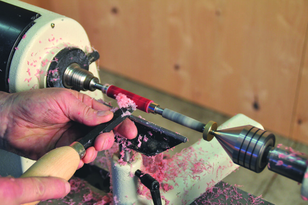 Man crafting with lathe, shaping material.
