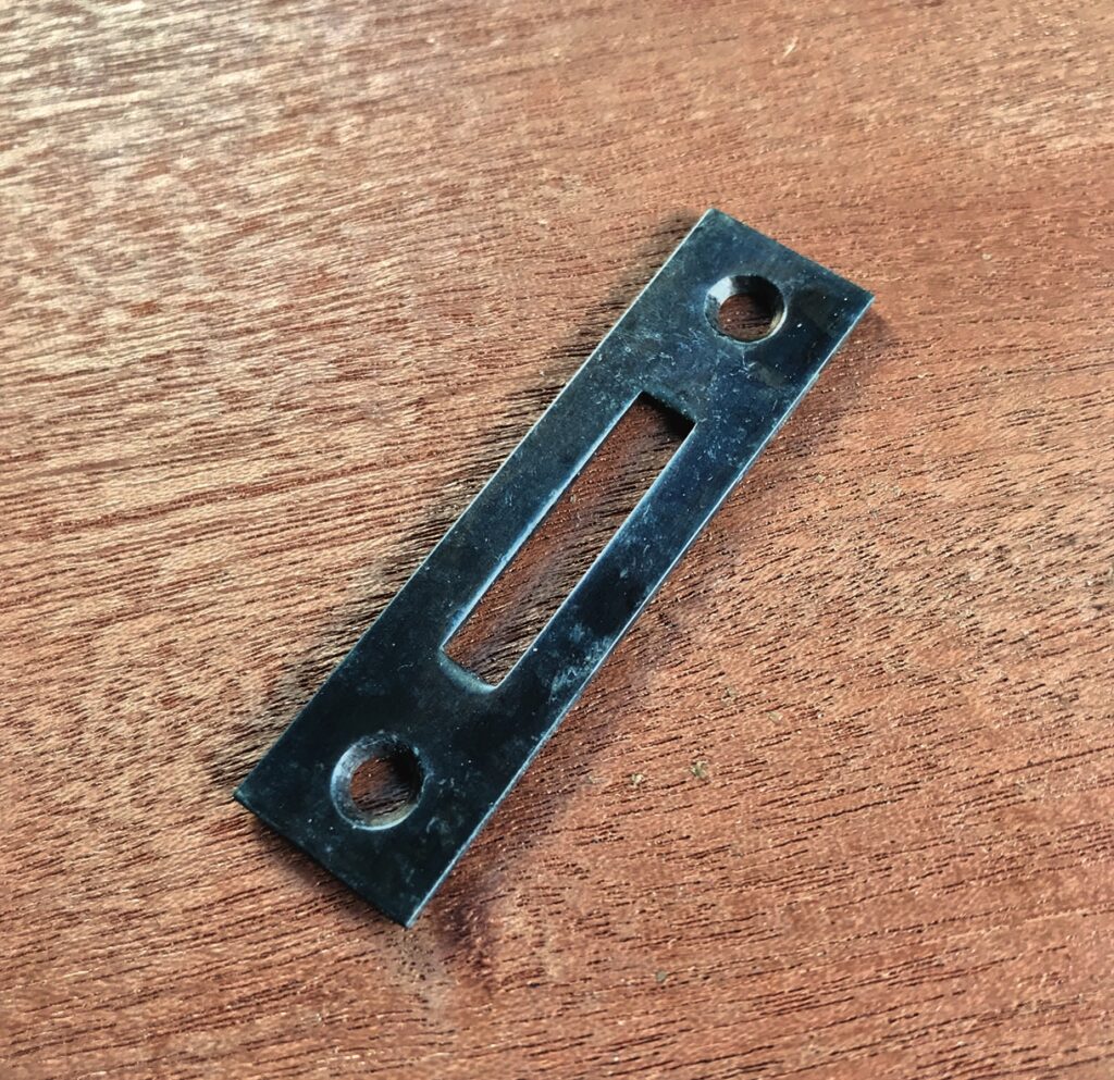 Metal plate with holes on wooden surface