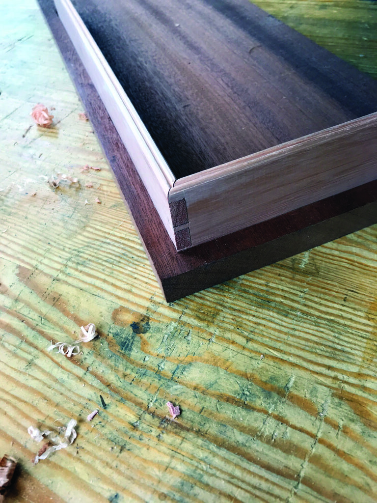 Wooden drawer on workshop table with shavings.