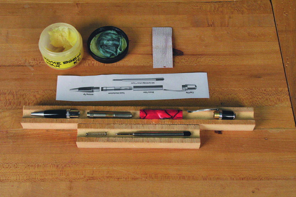 Components for crafting handmade pens on wood table.
