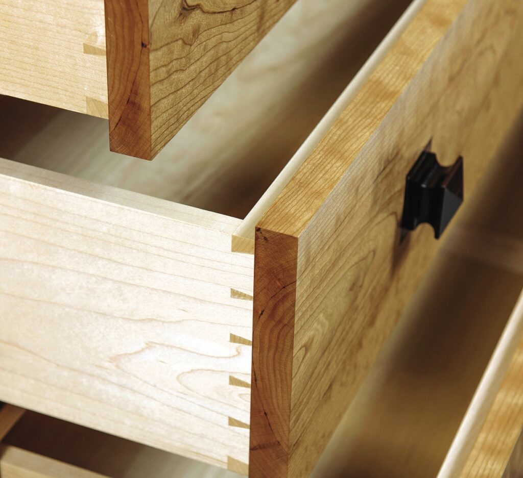Close-up of open wooden dovetail-jointed drawer.